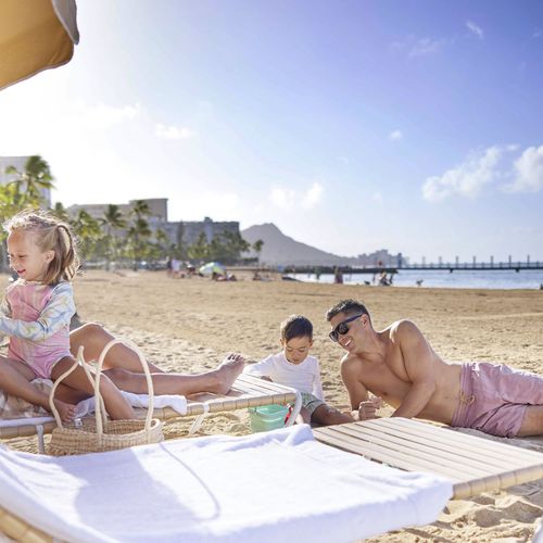 Family enjoying beach activities at Waikiki Beach lagoon